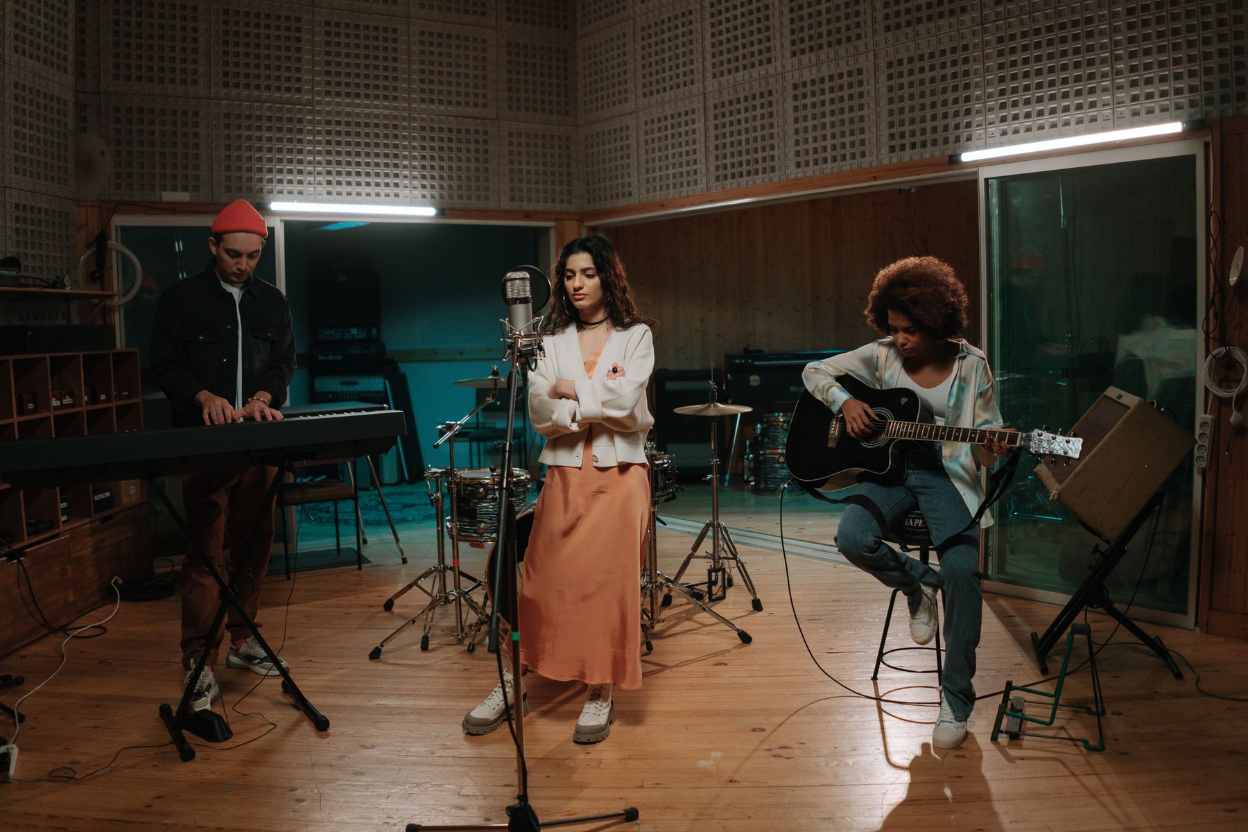 A singer, keyboard player and guitarist rehearsing together